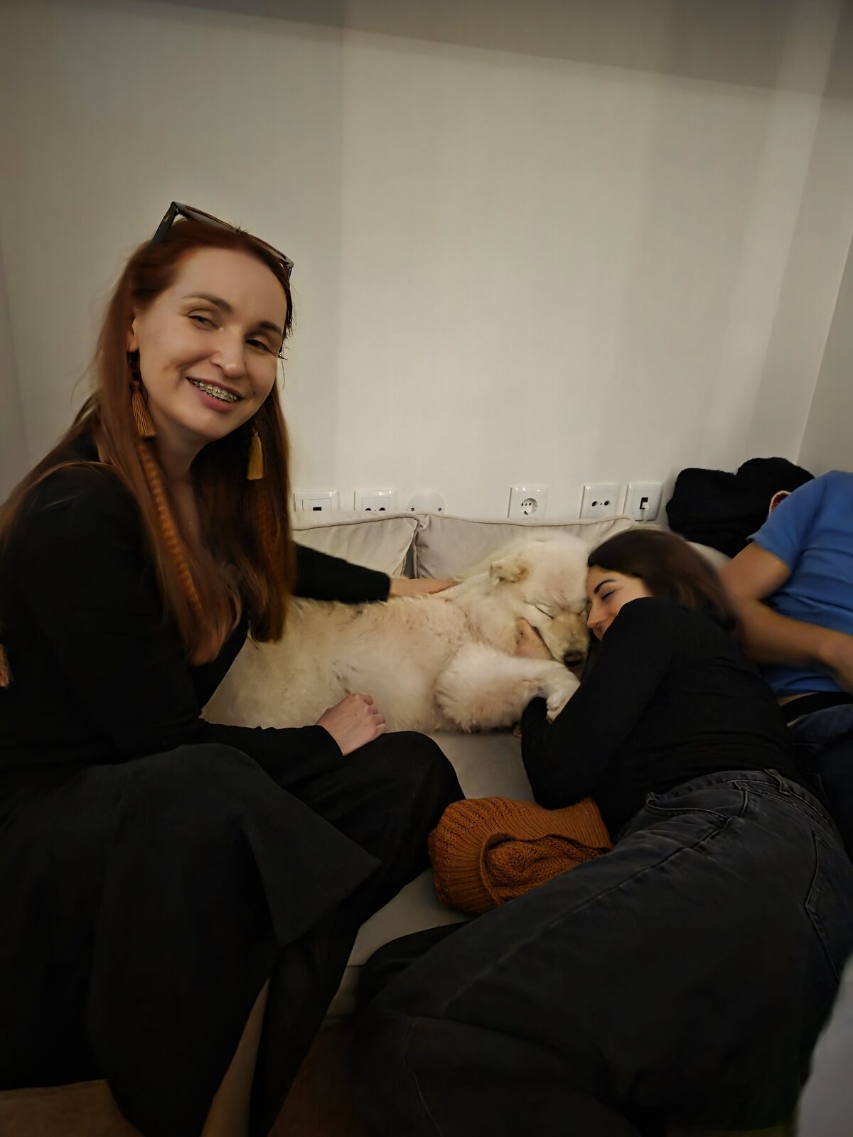 Residents and the house husky together on the sofa