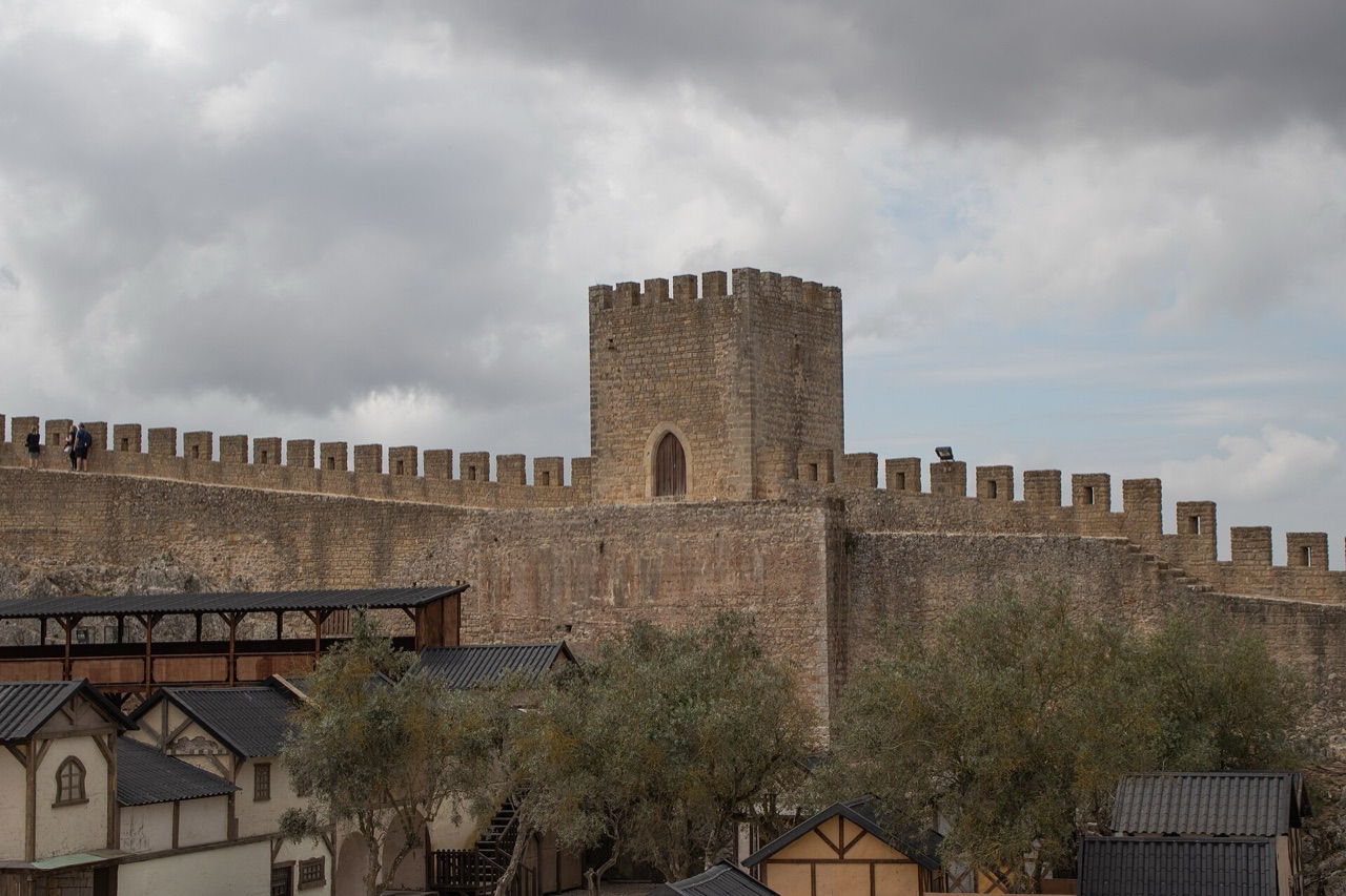 Castle walls above the timber taverns of the Óbidos medieval market grounds